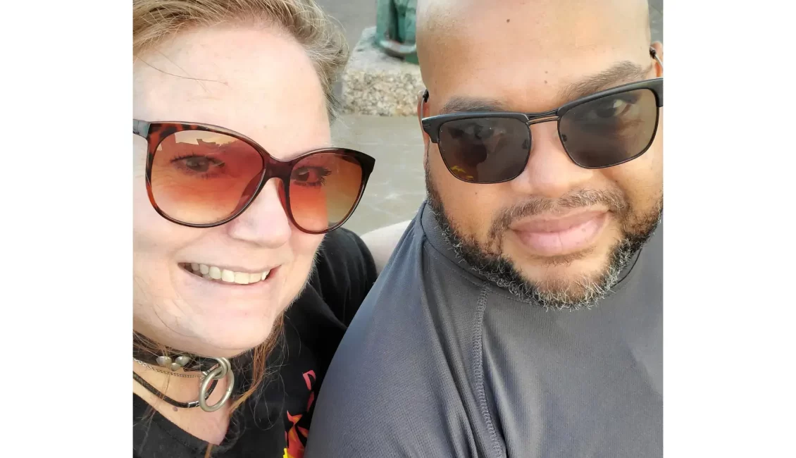 An image of Invictuz and BebeBlueEyes on the day of Bebe's collaring. She is wearing her Leather collar with a silver ring and they are both smiling at the camera