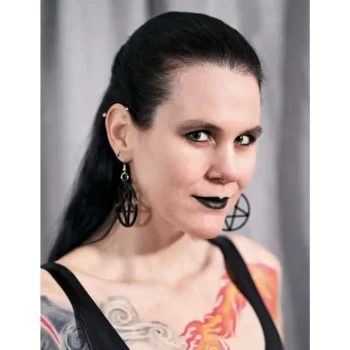 An image of Thista Minai. She is looking at the camera and is wearing black lipstick.